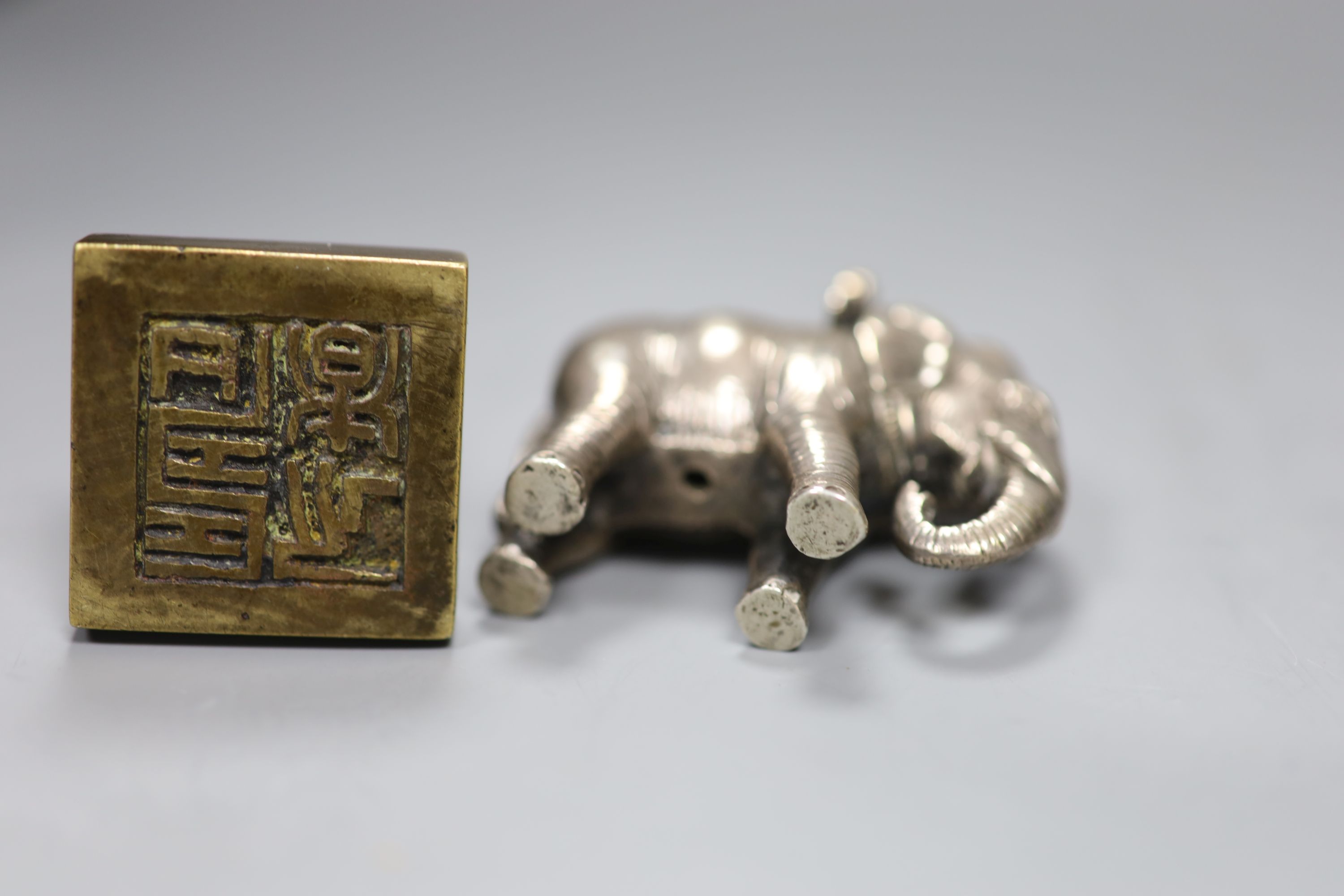 A group of Chinese bronze seals and a white metal elephant